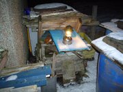 COBBLED COLEMAN LANTERN IN THE WOOD PILE..JPG